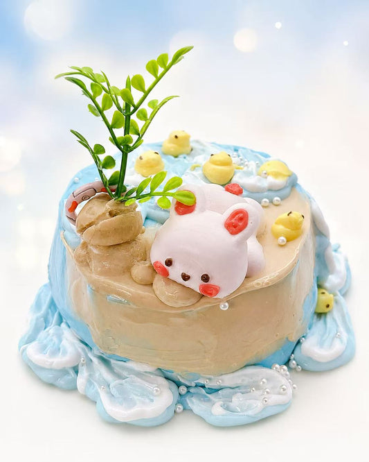 Front view of Bunny Beach Cake Taba Squishy showing the bunny, blue ocean waves, duck details, sandy cake top, and creamy handmade silicone texture.