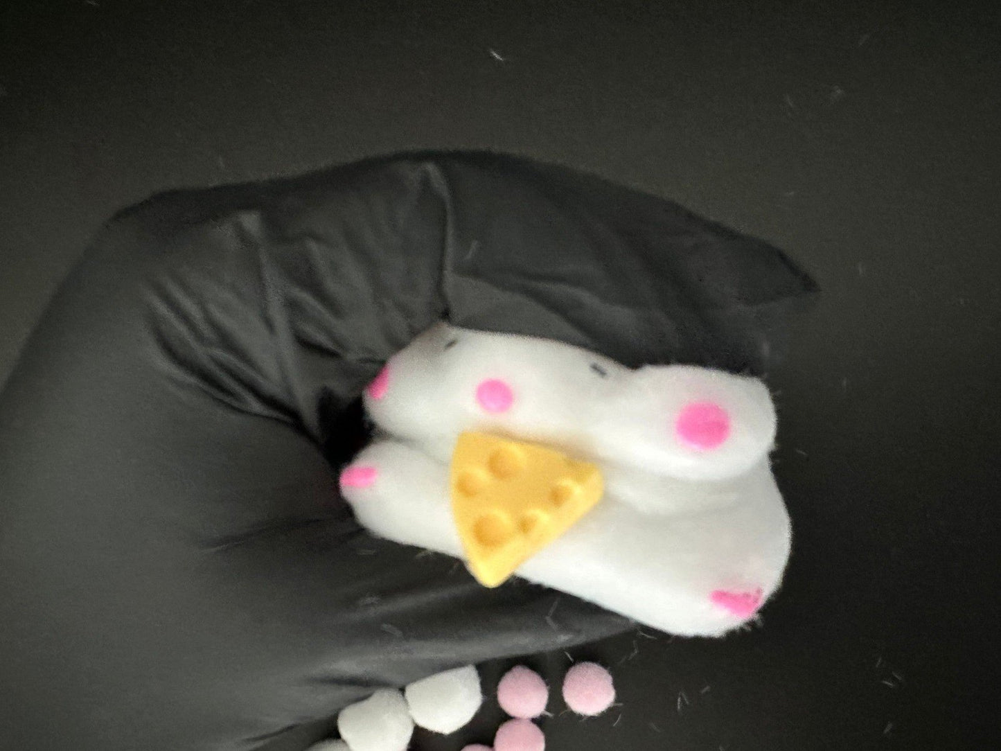 Side angle shot of cheese stealing hamster squishy toy, showing detailed 3D texture and soft squishy design.