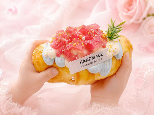 Hand holding the Dreamy Peach Croissant Taba Squishy, showing its soft handmade silicone texture, peach dessert design, and cute collectible size.