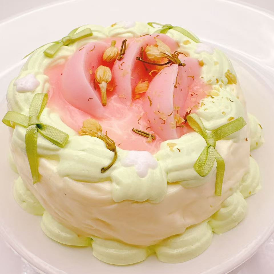 Front view of Jasmine Peach Garden Cake Taba Squishy, handmade silicone cake squishy with soft cream layers, peach jelly center and delicate jasmine details