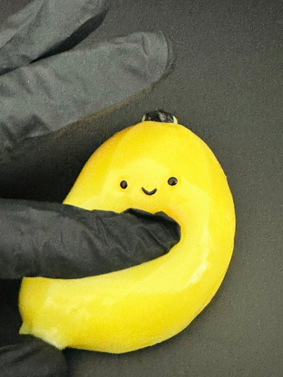 Side angle view of kawaii banana squishy toy, highlighting 3D shape, soft texture, and playful banana curve.