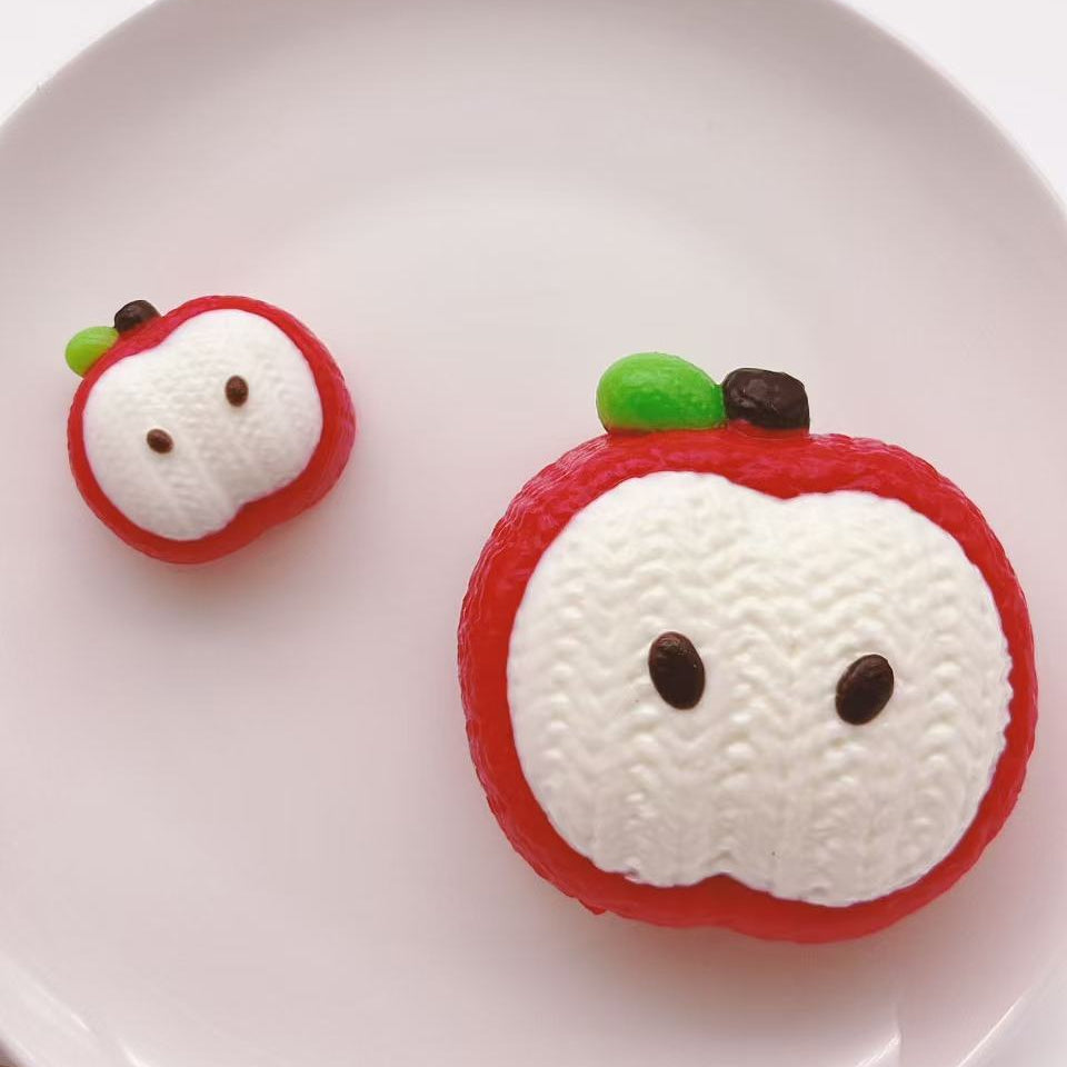 knitted apple taba squishy, handmade silicone squishy with cute face, soft stress relief toy, minimal clean background