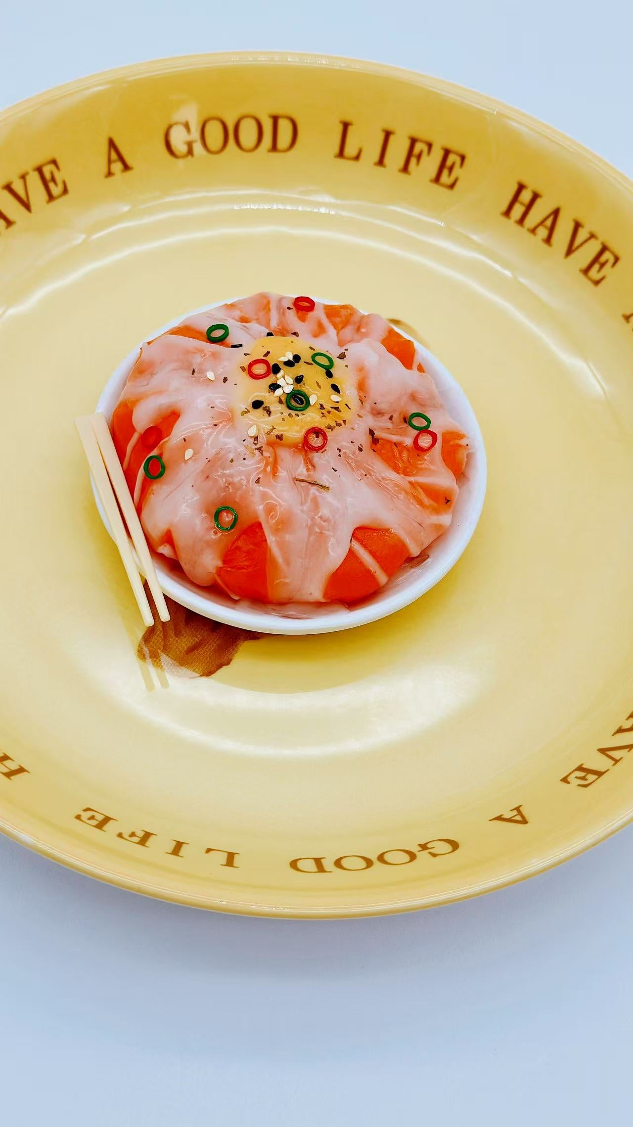Angled view of Salmon Don Bowl Squishy with glossy salmon slices and miniature chopsticks on the side.