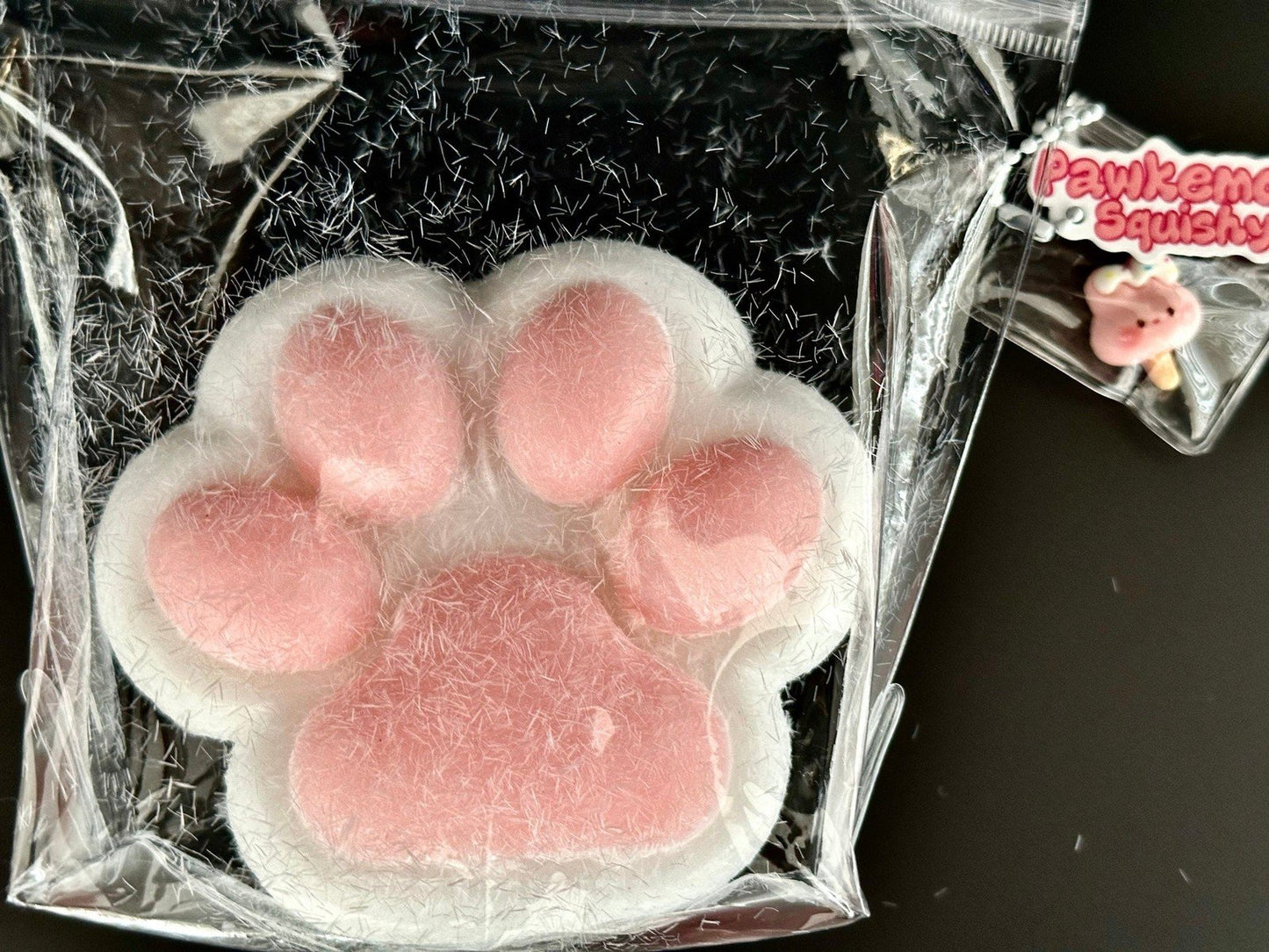Ultra soft cat paw squishy packaged inside transparent bag, showing fluffy texture and pastel color ideal for squishy lovers.