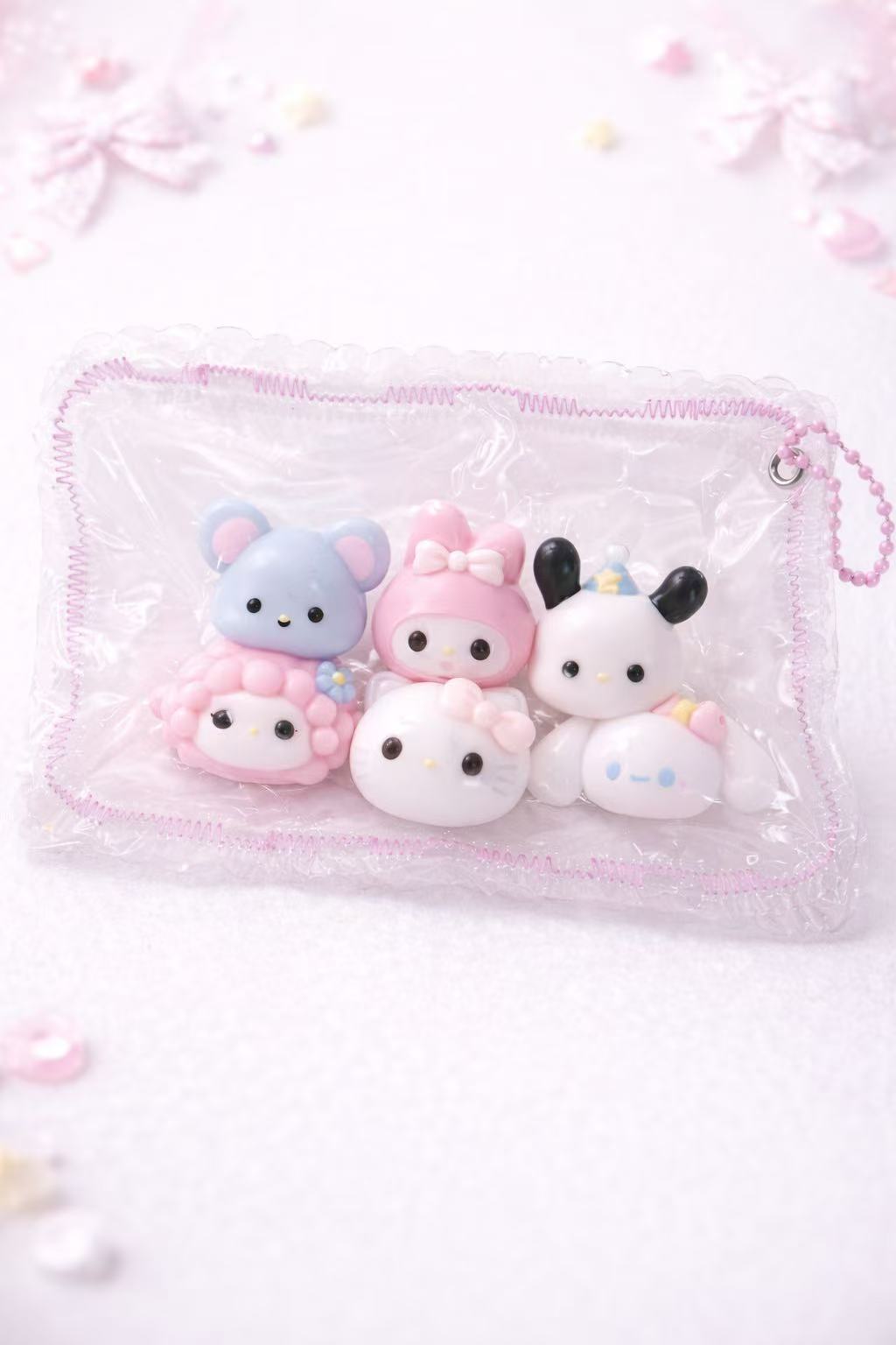 Set of cute taba squishy silicone toys in a clear pouch on a light pink background