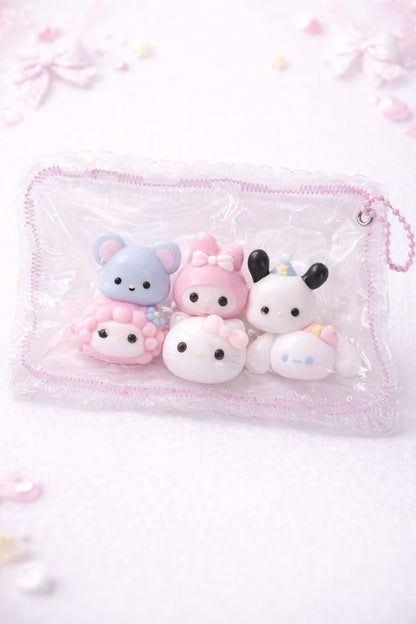 Set of cute taba squishy silicone toys in a clear pouch on a light pink background
