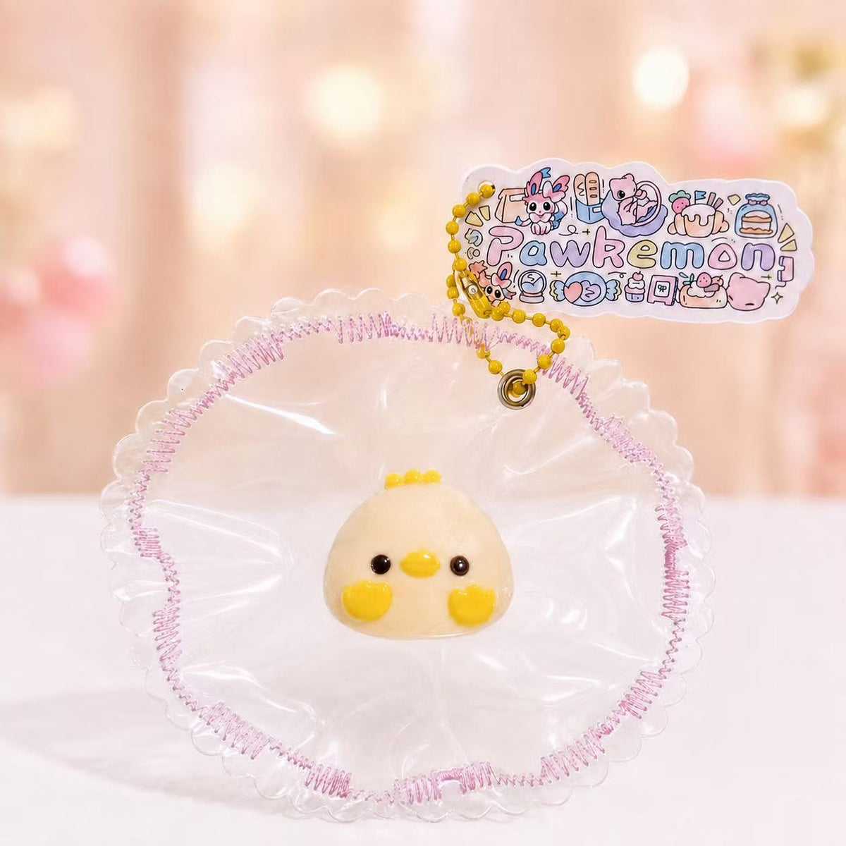 Mini Chick Taba Squishy by Pawkemon Squishy in a clear pink-trimmed bag, featuring a soft yellow chick design