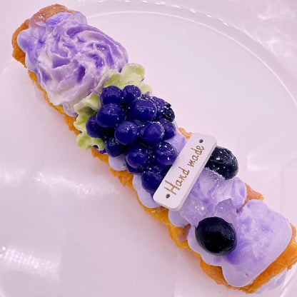 Grape Pastry Taba Squishy — ultra realistic handmade silicone squishy topped with whipped cream and fresh blueberry details.