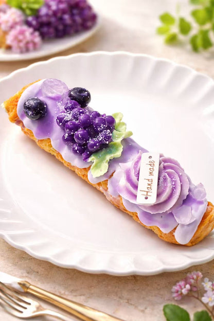 Handmade grape blueberry dessert squishy on elegant white plate, realistic purple fruit dessert taba squishy with detailed silicone texture