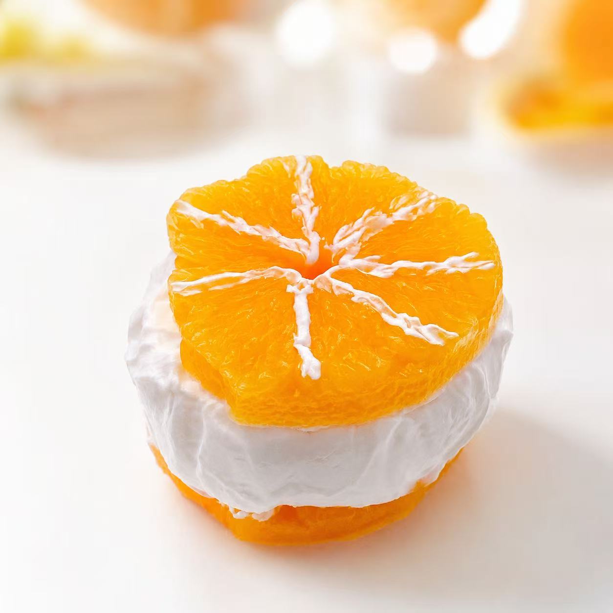Sliced orange Taba Squishy with white cream filling on a white background