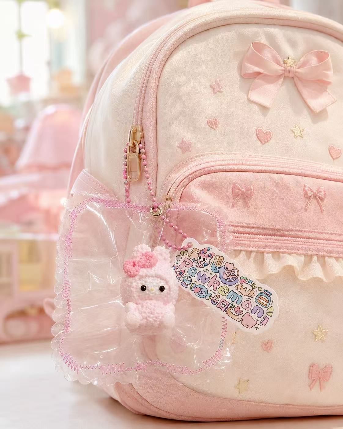 Pink Bunny Taba Squishy hanging as a cute bag charm from a pastel children’s backpack, with clear packaging, pink bead chain, and Pawkemon Squishy tag.
