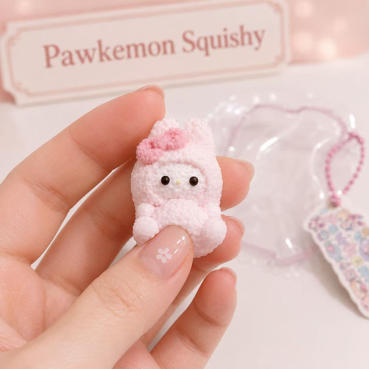 Close-up of the Pink Bunny Taba Squishy showing its detailed pink bow, textured handmade surface, glossy black eyes, and soft pastel finish.