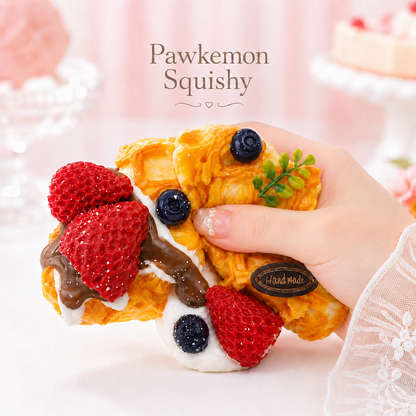 Hand holding and gently squeezing Berry Blossom Waffle Taba Squishy, a handmade dessert squishy with strawberries, blueberries, cream, and chocolate drizzle by Pawkemon Squishy.