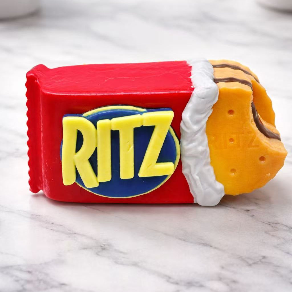 Handmade buttery cracker taba squishy with realistic snack packaging design, soft silicone texture and bite detail, sensory stress toy