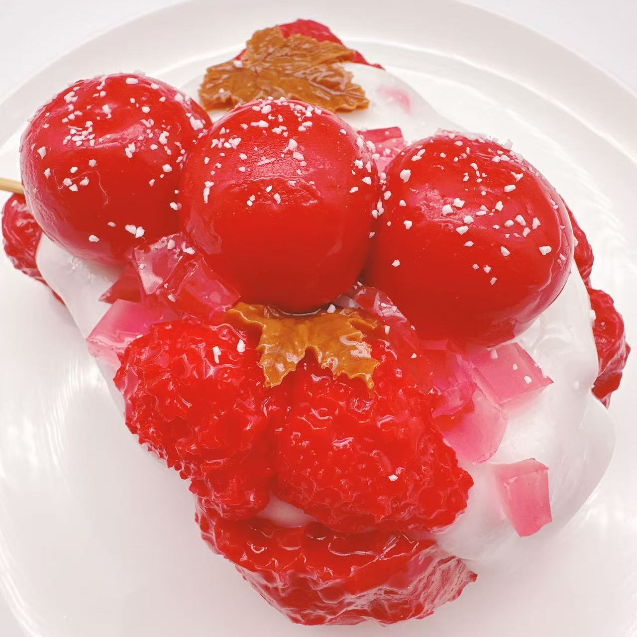 Top view of Candy Apple Strawberry Toast taba squishy showing candy apple skewer, jelly cubes and strawberry toast texture, handmade silicone sensory toy
