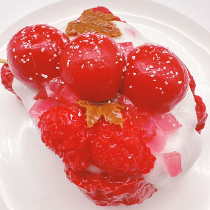 Top view of Candy Apple Strawberry Toast taba squishy showing candy apple skewer, jelly cubes and strawberry toast texture, handmade silicone sensory toy
