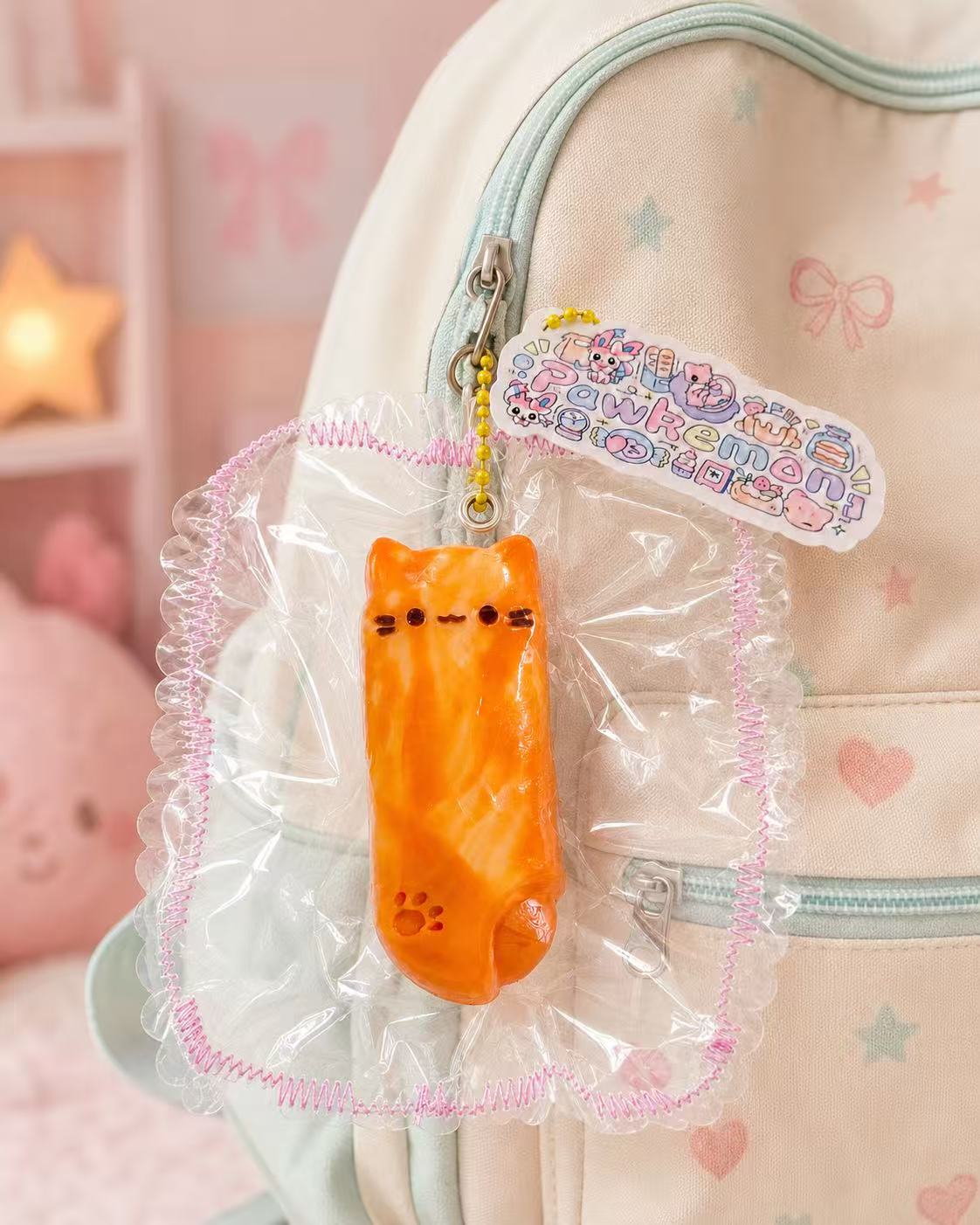 Cheese Kitty Bar Taba Squishy hanging from a pastel children’s backpack as a cute bag charm, with clear packaging, yellow bead chain, and handmade details.