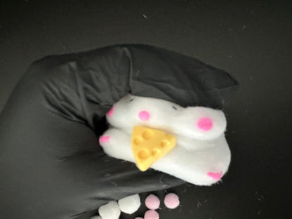 Side angle shot of cheese stealing hamster squishy toy, showing detailed 3D texture and soft squishy design.