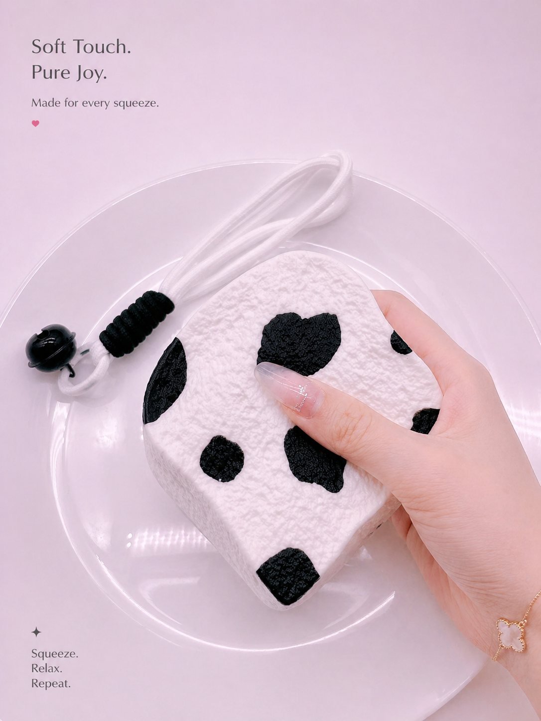 Hand holding a Cow Milk Toast Taba Squishy by Pawkemon Squishy, showing its soft handmade silicone texture, black and white cow print design, rounded toast shape, and cute charm strap.