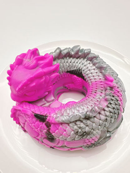Top view of a handmade dragon coil taba squishy showing coiled body and textured silicone scales