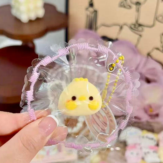 Hand holding an Eggie Chick Taba Squishy in clear frilled packaging. Adorable yellow chick design with soft slow-rising texture.
