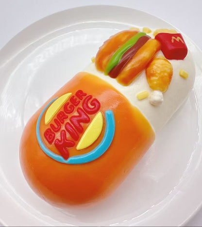 Top view of fast food burger capsule taba squishy showing detailed hamburger and fries silicone texture
