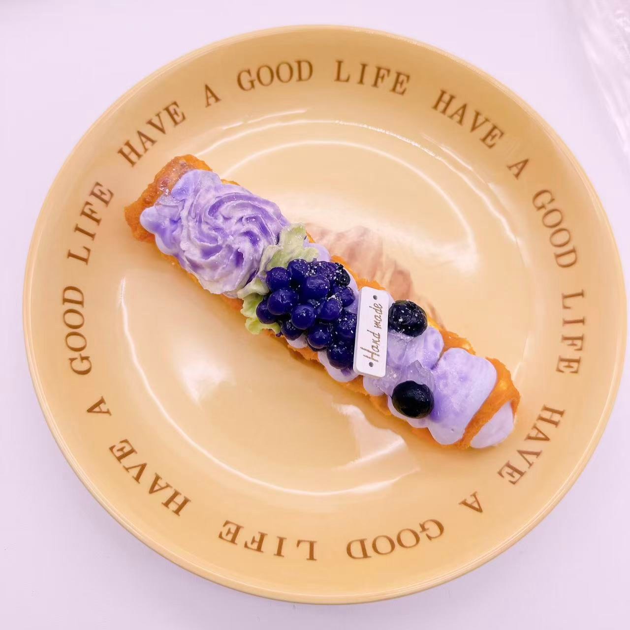 grape Pastry Taba Squishy displayed on plate — handmade realistic squishy horn bread with blueberry topping and purple cream. Cute stress relief squishy, kawaii collectible toy for squishy fans.”