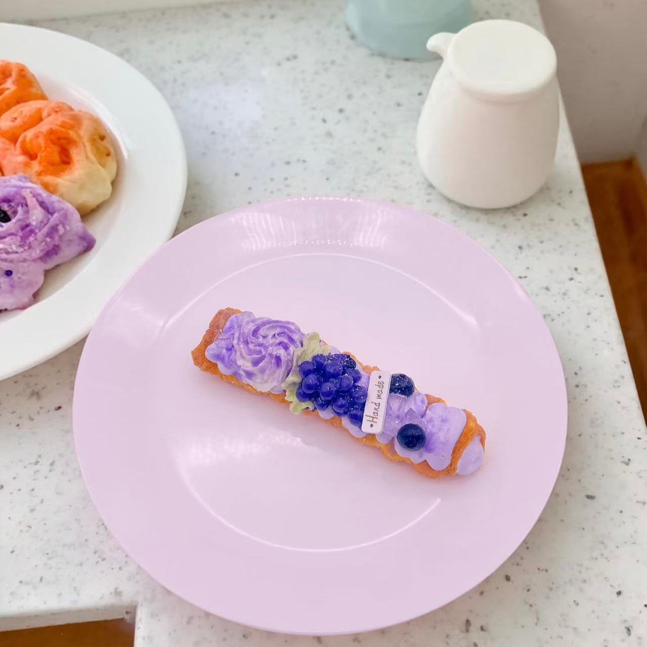 Handmade Grape  Pastry Taba Squishy on plate — hyper realistic silicone squishy pastry with blueberry clusters and cream decoration. 