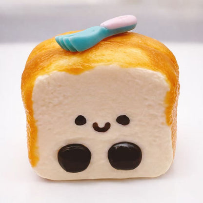 JC toast taba squishy featuring a cute  face inside a golden toast design, made of soft silicone with a slow-rise texture, photographed on a clean white background.
