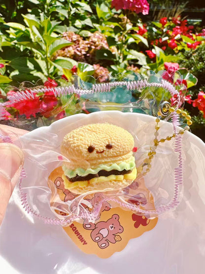 Mini burger squishy in jellycat style with cute facial expression and layered texture.
