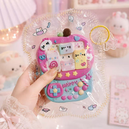 Hand holding a handmade Pink Arcade Machine Taba Squishy showing its soft silicone texture, pastel buttons, and retro game details