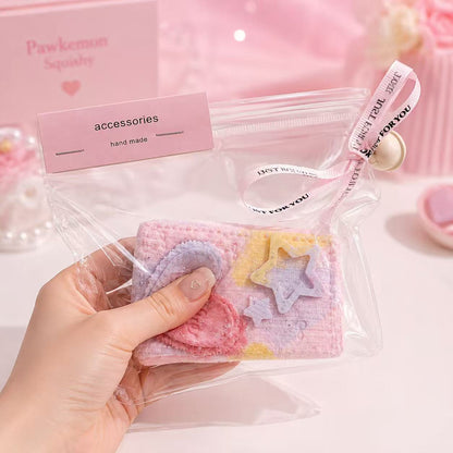 Hand holding the Pink Denim Brick Taba Squishy, showing its soft handmade silicone texture, pastel denim-style brick design, clear zipper pouch, and cute charm details.