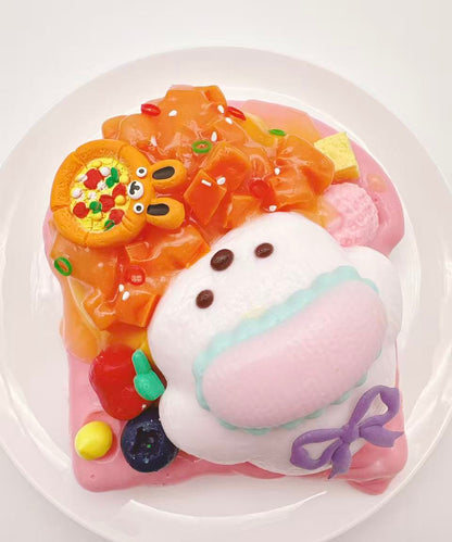 Top view of puppy salmon toast taba squishy with salmon-inspired topping, fruit accents and soft creamy handmade silicone texture
