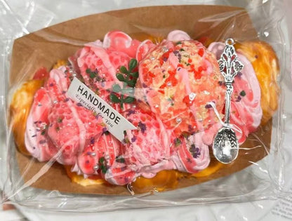 Angled close-up of Rosé Royale croissant squishy toy in packaging, highlighting jelly texture and gold flakes