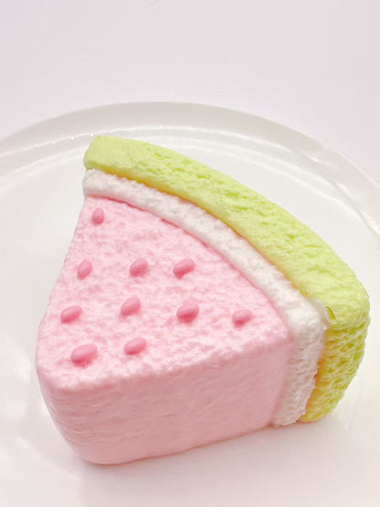 Watermelon cake taba squishy side view, handmade silicone dessert squishy showing watermelon rind and creamy layers, minimal clean background