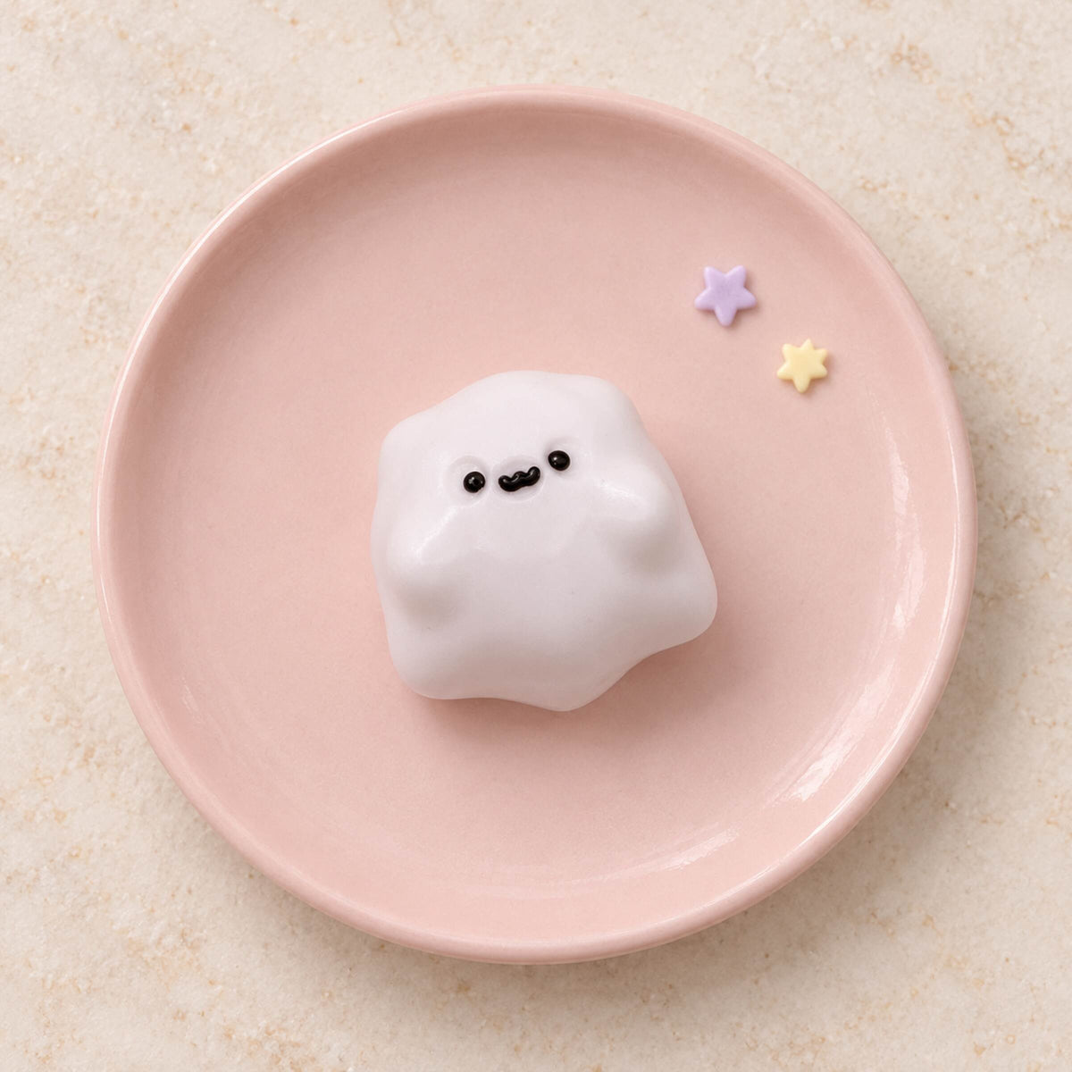 Single white mini ghost Taba Squishy centered on a blush pink plate with two tiny pastel star accents.