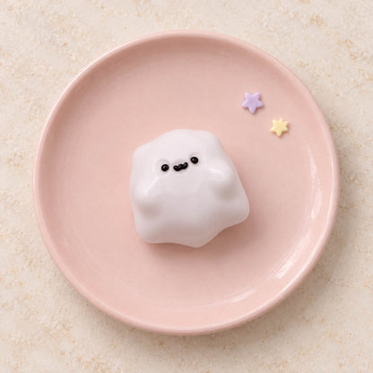 Single white mini ghost Taba Squishy centered on a blush pink plate with two tiny pastel star accents.