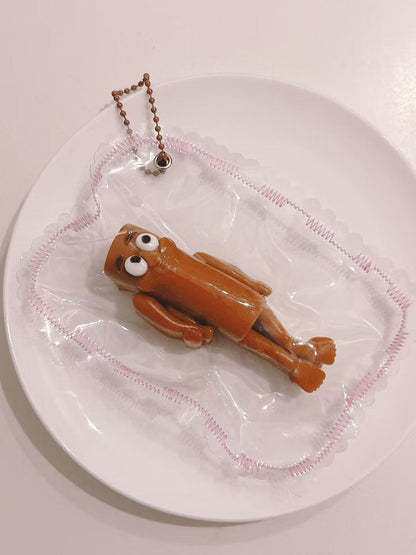 Side view of a handmade Wooden Man Taba Squishy showing its slim 3D character shape and transparent packaging