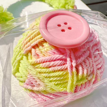 Handmade yarn ball Taba Squishy in pink and green with a cute button design, stress relief toy, kawaii collectible.
