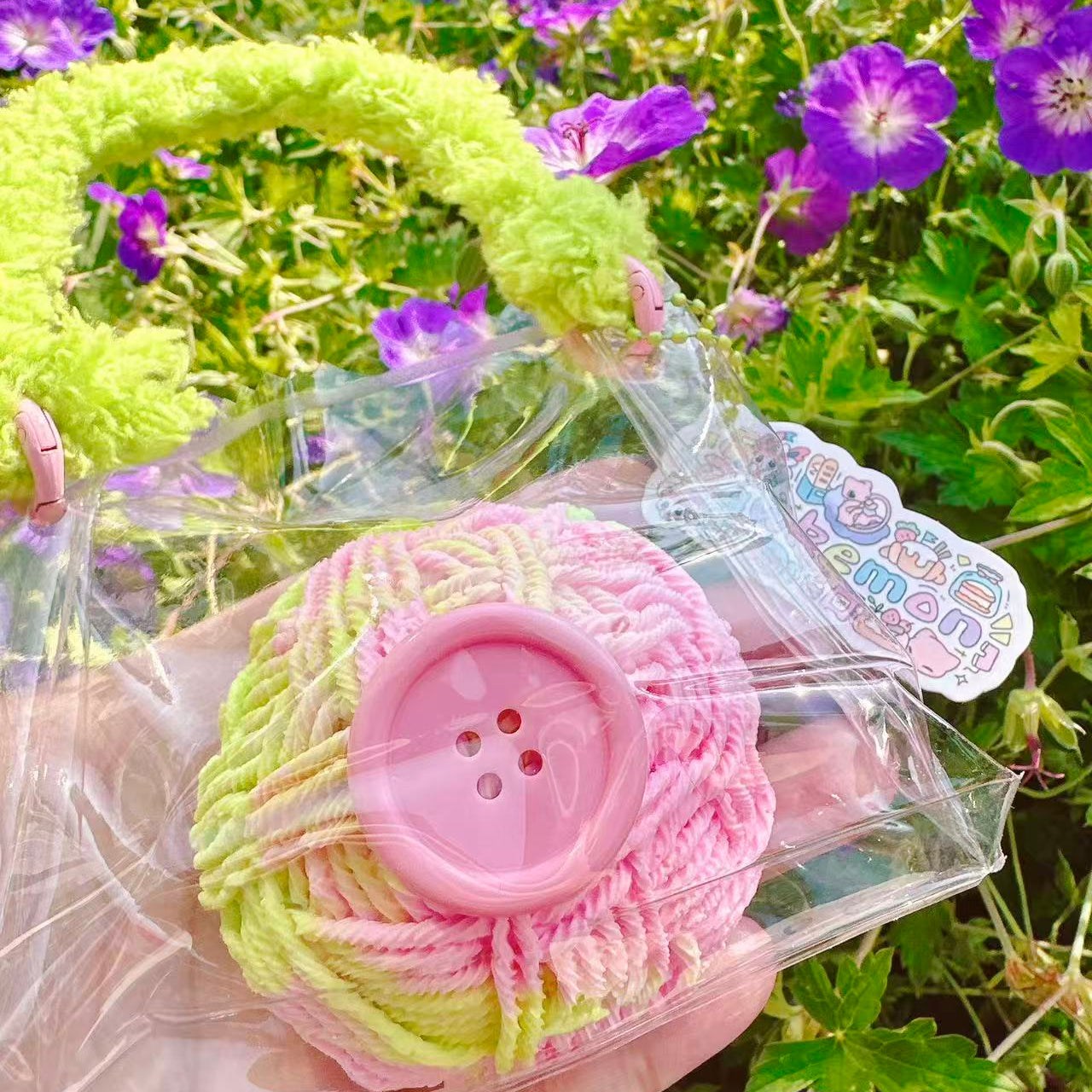 Cute yarn ball squishy with button detail and braided handle, soft stress relief toy, perfect kawaii gift.