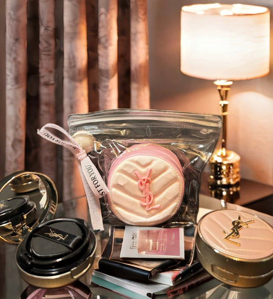 YSL-style cushion squishy displayed on makeup vanity with luxury beauty products and warm lighting
